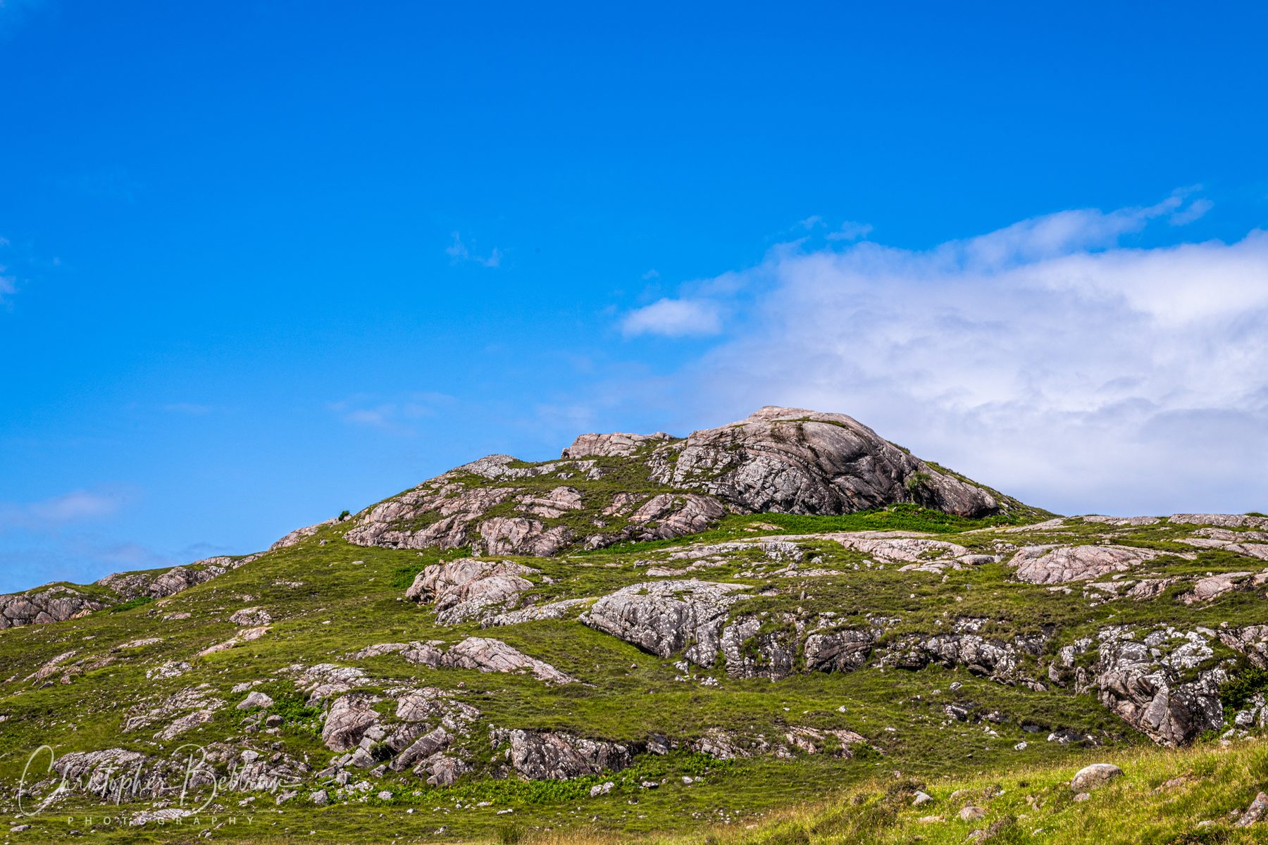 Rocky highland hills under a blue sky · Scotland