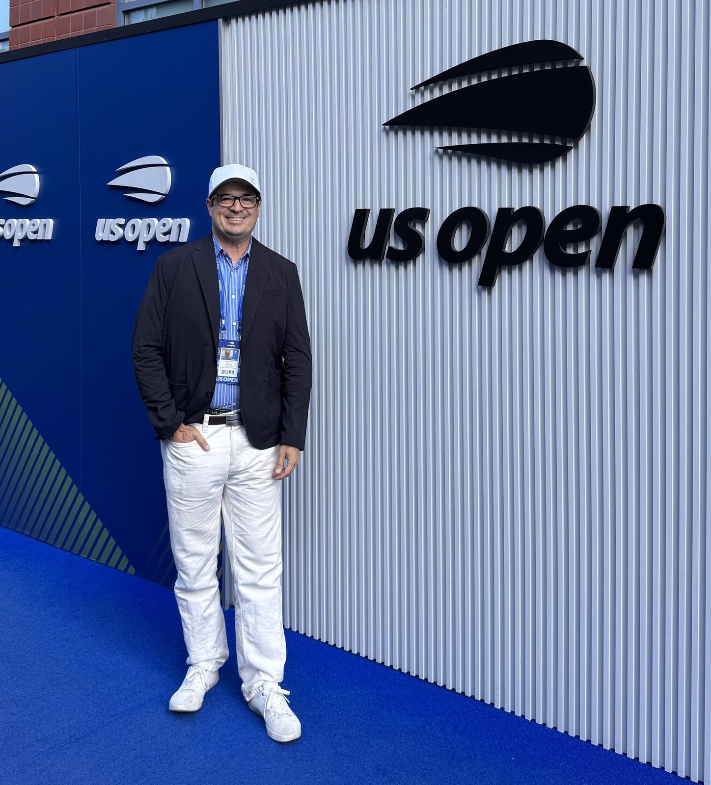 Christopher Beltran beneath the US Open sign at Flushing Meadows